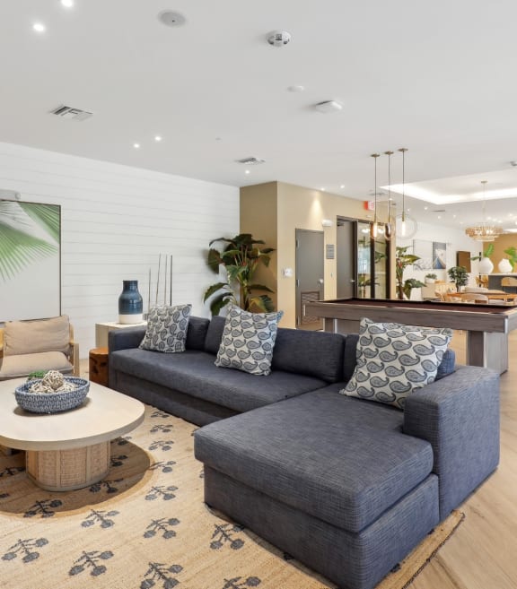resident lounge with couches and chairs and a table at Westgate on University in Lauderhill, FL