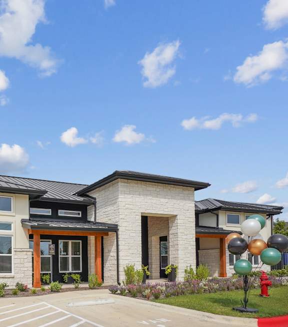 A large black and beige building with a grassy area in front.