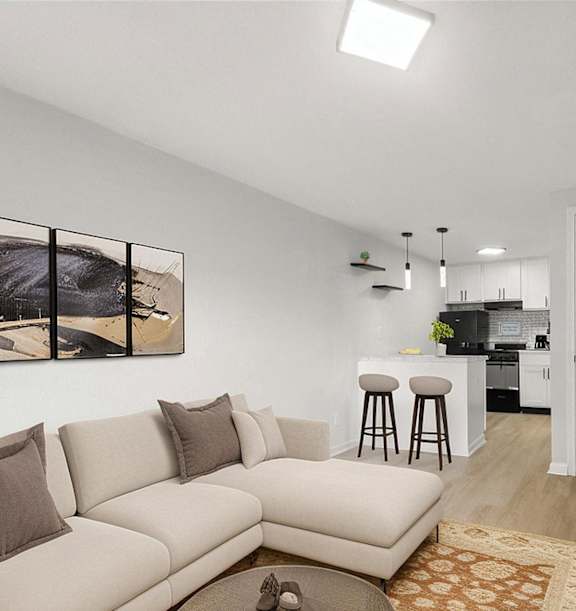a living room with a couch and a coffee table and a kitchen