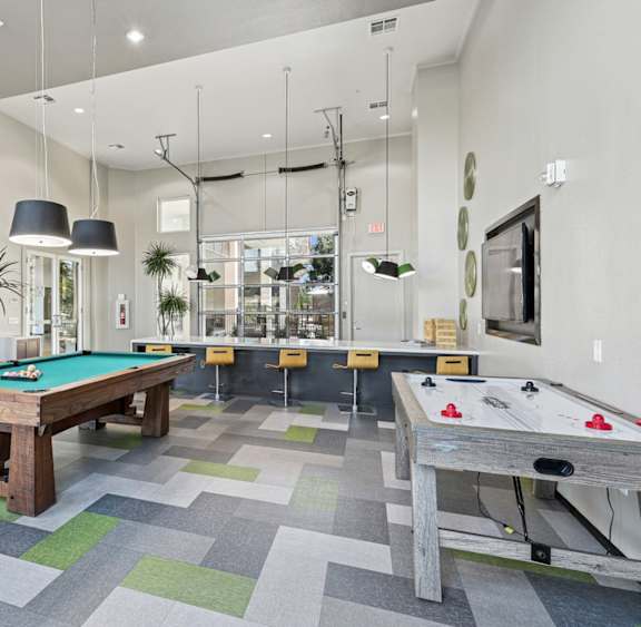 Game room with pool table and air hockey at GreenVue apartments in Richardson, TX
