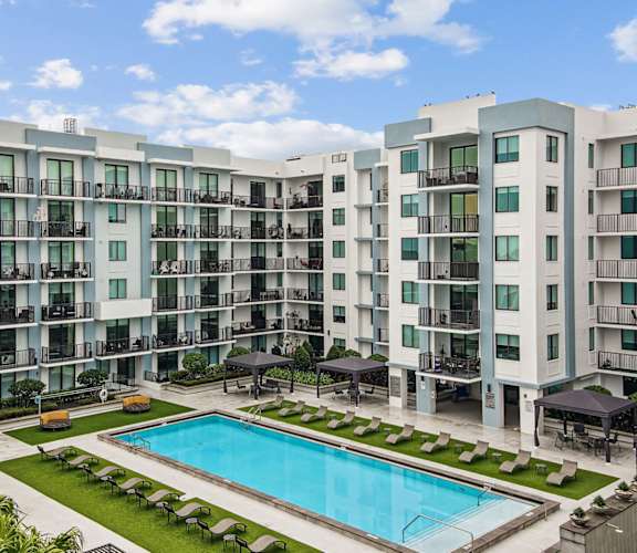 Pool area with apartment balconies overlooking the pool at Twenty2 West luxury apartments in Miami, FL