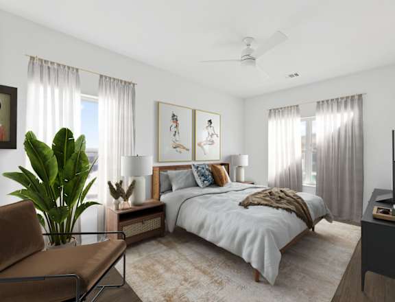 A bedroom with a large bed, a chair, and a plant.