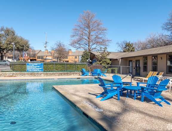 A pool with blue chairs and a sign that says "No Diving".