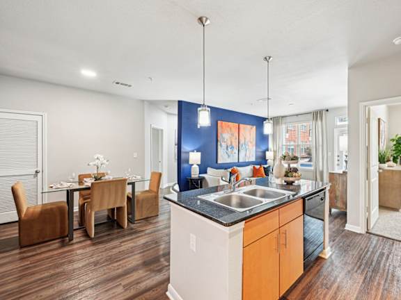 Open-concept living room and dining area with modern kitchen at The Grand at Upper Kirby apartments in Houston, TX