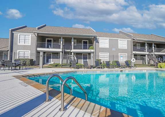 A swimming pool in front of apartment buildings at The Oasis apartments in Bossier City, LA