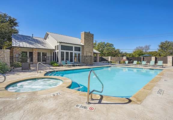 Our resort-style pool with a hot tub behind the leasing office at On the Green apartments in Austin, TX