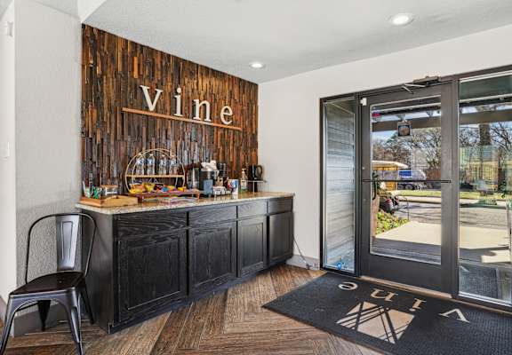 A bar area with a wooden backdrop and a chair in front of it.
