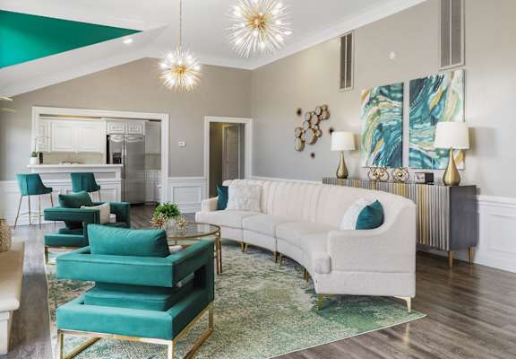 a living room with a white couch and turquoise chairs