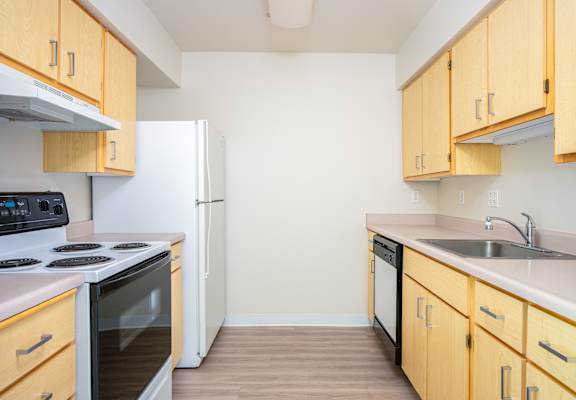A kitchen with wooden cabinets and a white refrigerator.