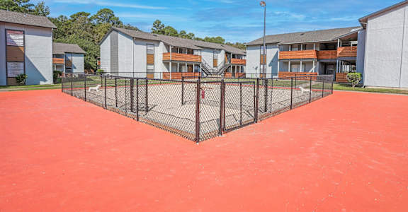 A fenced dog yard with apartment buildings in the background at The Marq in Shreveport, LA