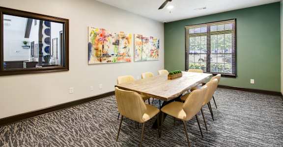a conference room with a table and chairs and a ceiling fan at Columbus Apartments in Columbus, Georgia, GA