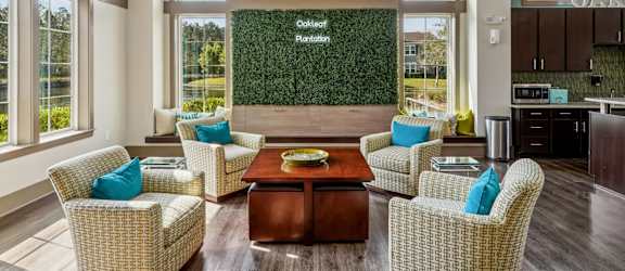 A living room with a green wall and wicker chairs.