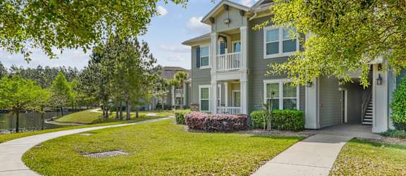 A residential building with a green lawn in front.