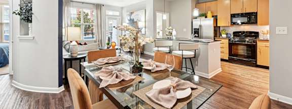 Stylish dining area and modern kitchen with pendant lighting at The Grand at Upper Kirby apartments in Houston, TX