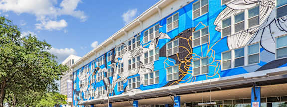 A building with a blue and white mural of fish on the side.