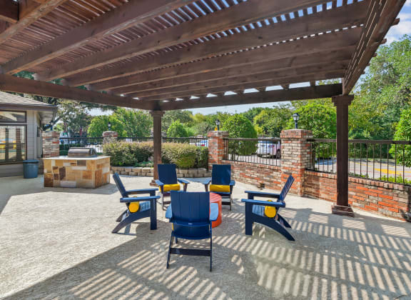 a patio with a pergola and tables and chairs