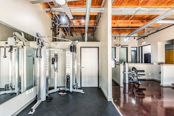 two views of a fitness room with weights and cardio machines