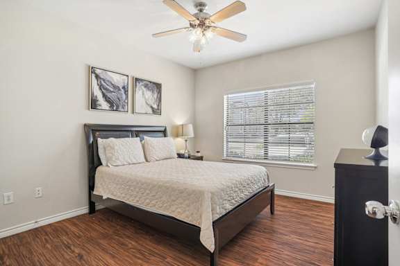 a bedroom with a bed and a ceiling fan