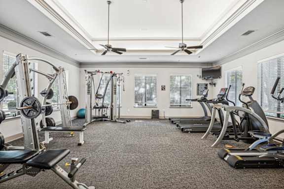 a gym with exercise machines and ceiling fans