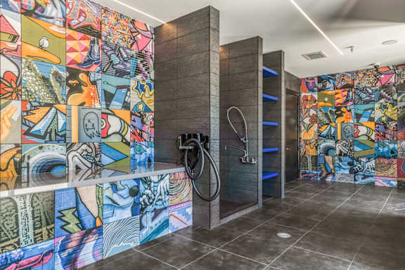 A bathroom with a mosaic tile wall and a shower.