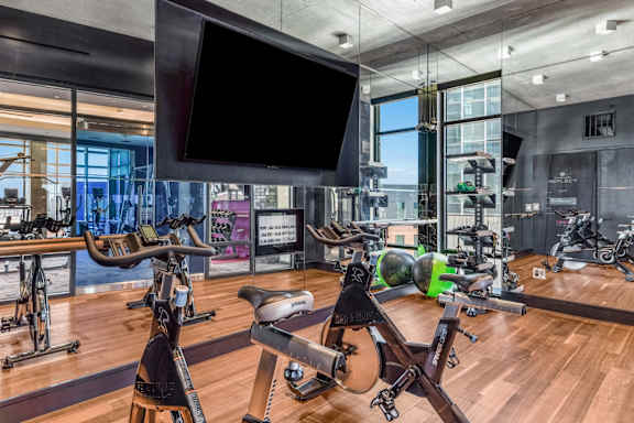 A gym with exercise equipment and a television screen.
