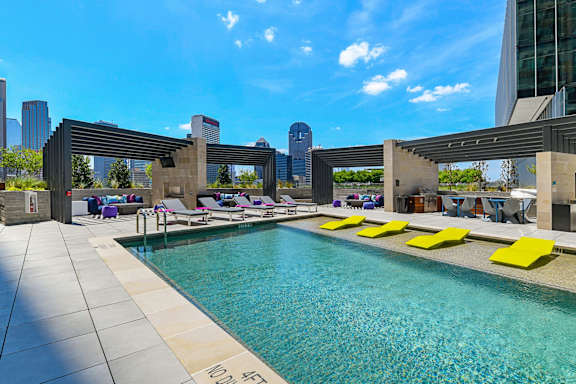 A pool area with a modern design and yellow sun loungers.
