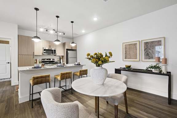 A modern kitchen with a dining table and chairs.