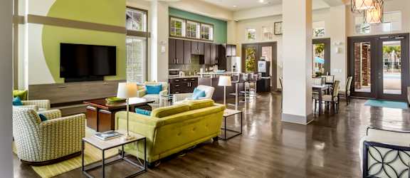 Large clubhouse with plenty of seating, TV, and a kitchen at Oakleaf Plantation in Jacksonville, FL