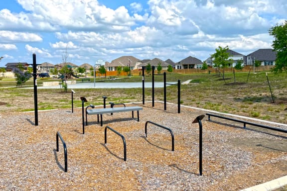 a park with a lake and houses in the background