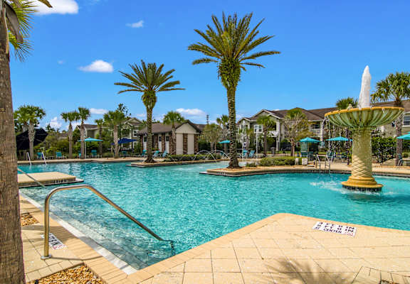 Swimming pool with palm trees and a fountain feature at Oakleaf Plantation in Jacksonville, FL