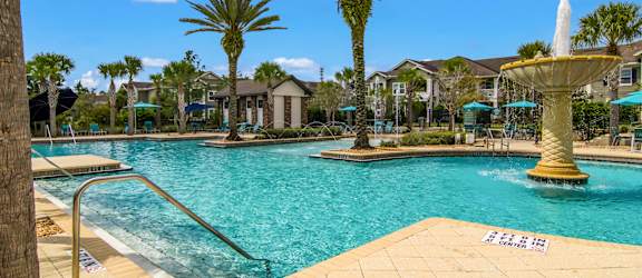Swimming pool with palm trees and a fountain feature at Oakleaf Plantation in Jacksonville, FL