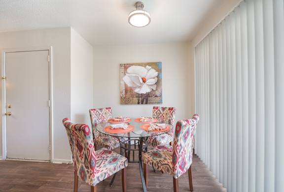A dining room with a table set for four.