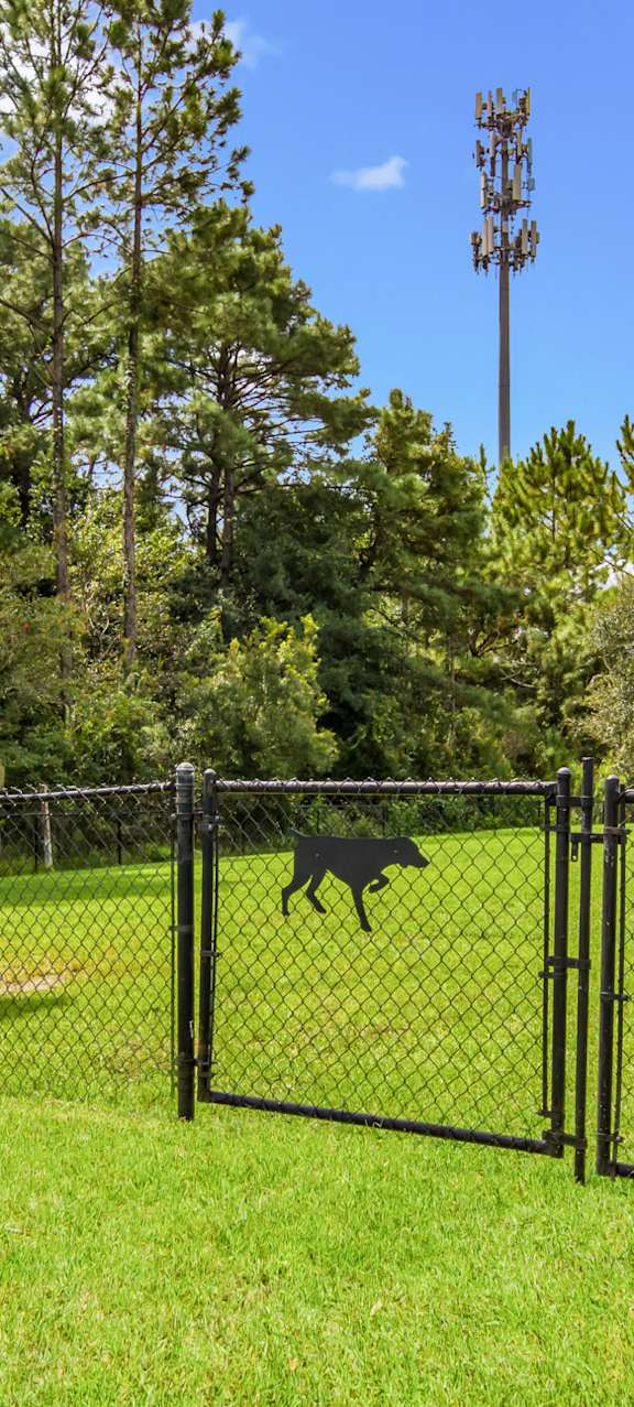 Dog park with a shaded bench for pet owners at Oakleaf Plantation in Jacksonville, FL