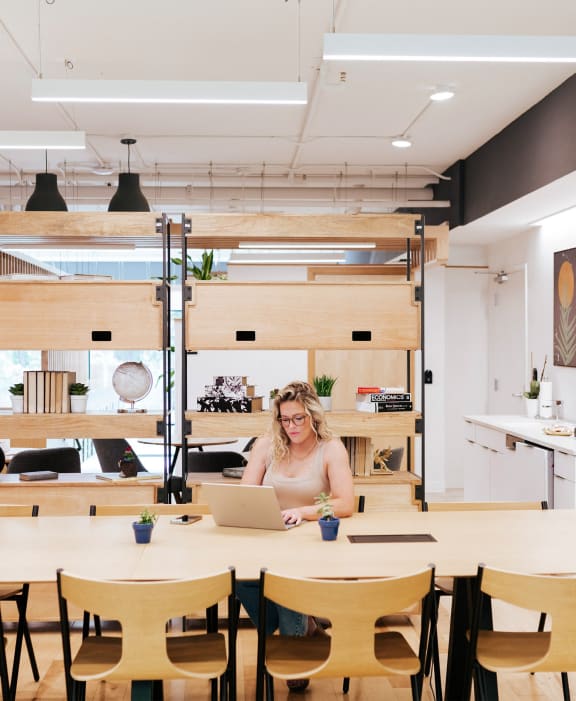 a woman sitting at a table with a laptop