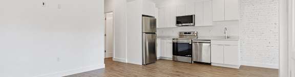a kitchen with white cabinets and a stainless steel refrigerator