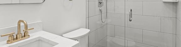a white bathroom with a shower and a sink