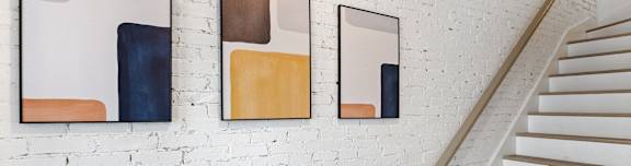 three mirrors hanging on a wall next to a staircase