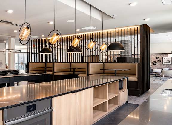 a kitchen with a large island and a row of lights