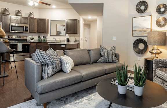 A living room with a grey couch and a grey armchair.