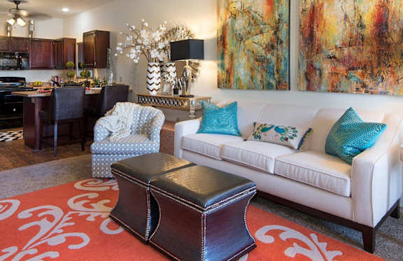 a living room and kitchen with a couch and a chair