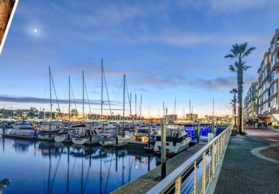a view of a marina with boats docked next to a building