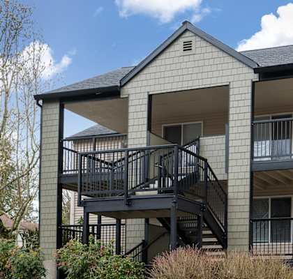 A modern two-story apartment building with a balcony on the second floor.