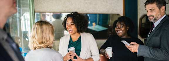 a group of people standing in a room talking