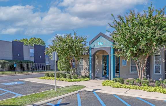 A parking lot with a blue building in the background.