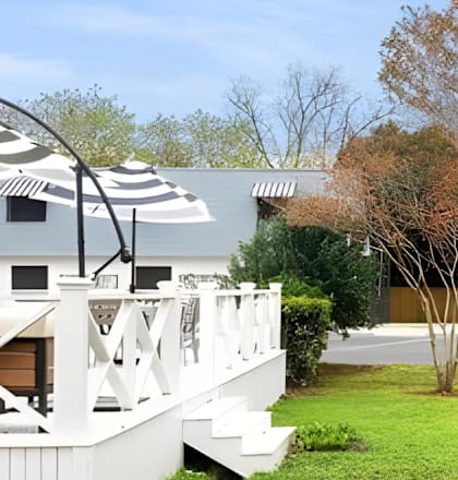 A white house with a deck and a hot tub.