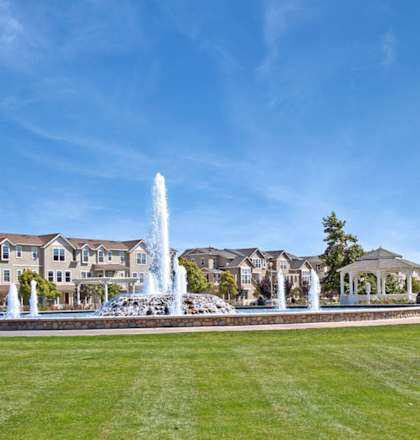 a fountain in a park in front of a house at The Vines at Riverpark, LLC, California