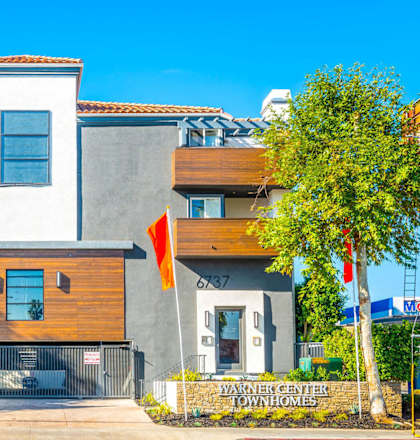 a house with two orange flags in front of it at Warner Center Townhomes, California, 91303