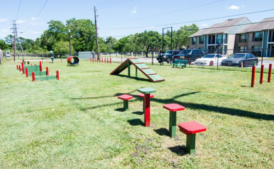 a park with a seesaw and benches in front of a building