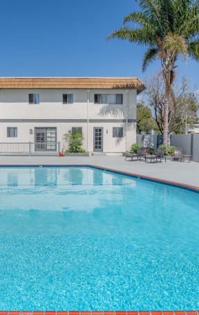 a swimming pool with a building in the background at Ocean Villas, Oxnard, CA