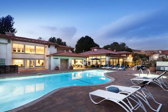 a swimming pool in front of a hotel at dusk